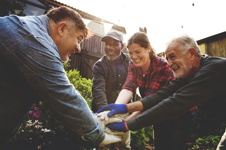 About Our Agency - Group of Cheerful Farmers Standing Outside Putting Their Hands Together