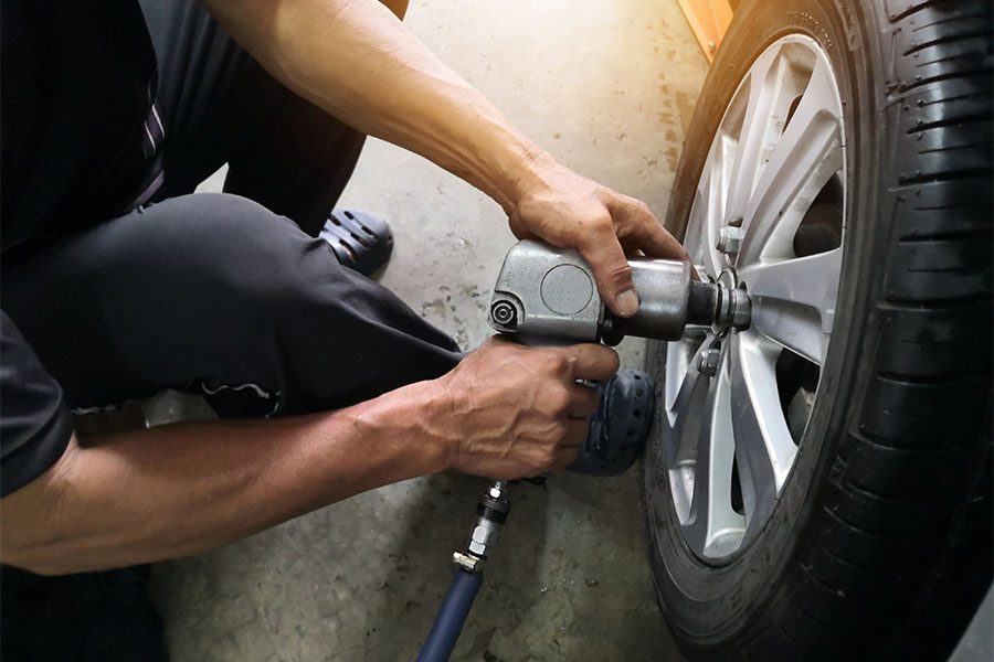 Specialized Business Insurance - Mechanic Changing Tires at a Repair Shop Garage